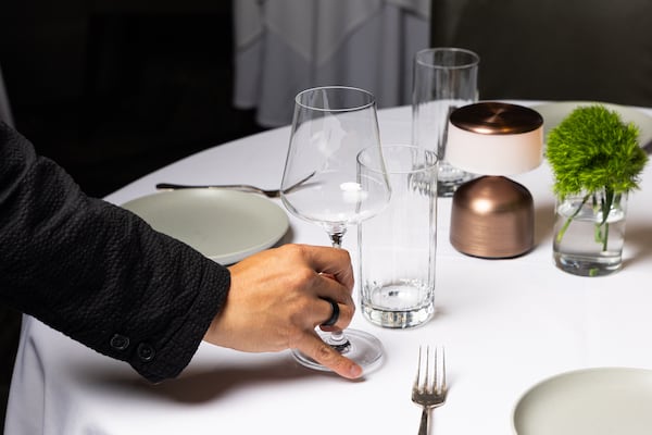 Aria was a James Beard Award nominee for Outstanding Hospitality in both 2025 and 2026. Remy Loet, the restaurant's sommelier, sets out wine glasses on a table before the start of dinner service at Aria on June 5, 2026. (Cameren Rogers for the AJC)