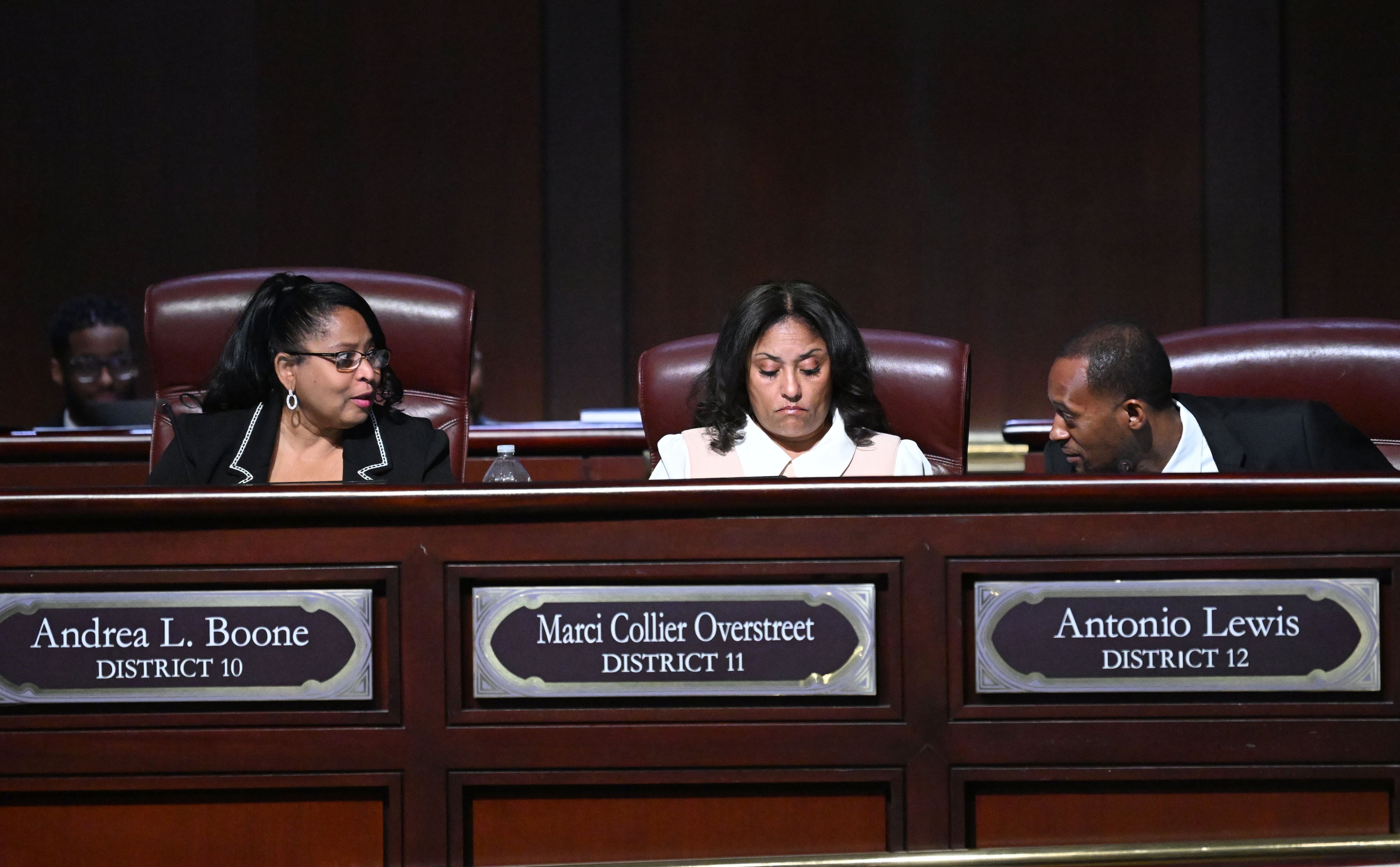 Andrea Boone, Marci Collier Overstreet and Antonio Lewis confer during a City Council meeting in Atlanta.