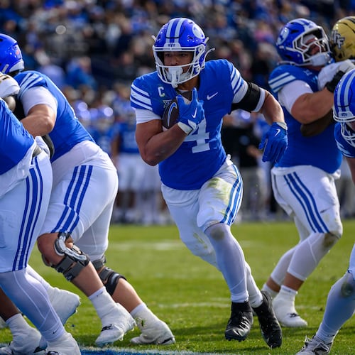 BYU running back LJ Martin (4) runs the ball in for a touchdown during the first half an NCAA college football game, Saturday, Nov. 29, 2025, in Provo, Utah. (AP Photo/Tyler Tate)