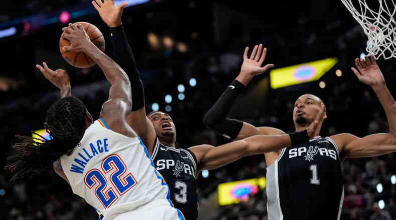 Oklahoma City Thunder guard Cason Wallace (22) shoots against San Antonio Spurs forward Keldon Johnson (3) in the second half of Game 6 in the Western Conference finals NBA basketball playoffs series, Thursday, May 28, 2026, in San Antonio. (AP Photo/David J. Phillip)
