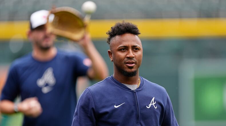 Injured Atlanta Braves second baseman Ozzie Albies heads back to the dugout after throwing before a baseball game against the Colorado Rockies, Friday, Aug. 9, 2024, in Denver. (AP Photo/David Zalubowski)