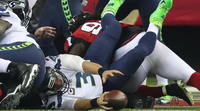 The Falcons defense upends Seahawks quarterback Russell Wilson in the end zone for a safety to cut the Seahawks lead to 10-9 during the second quarter in a NFL football NFC divisional playoff game on Saturday, Jan. 14, 2017, in Atlanta. Curtis Compton/ccompton@ajc.com