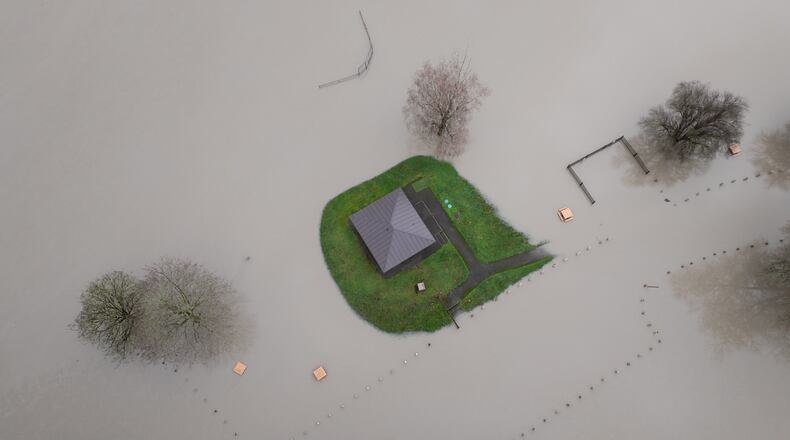 A home is surrounded by floodwaters near Twin Rivers Snohomish County Park in Arlington, Wash., Thursday, Dec. 11, 2025. (Erika Schultz/The Seattle Times via AP)