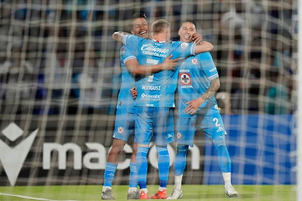 Angel Sepulveda of Mexico's Cruz Azul, left, is congratulated after scoring his side's 5th goal against Canada's Vancouver Whitecaps during the CONCACAF Champions Cup final soccer match in Mexico City, Sunday, June 1, 2025. (AP Photo/Fernando Llano)
