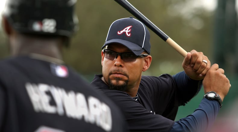 Former Brave David Justice demonstrates his batting stance to Jason Heyward, left, during spring training in 2012. Jason Getz/AJC file