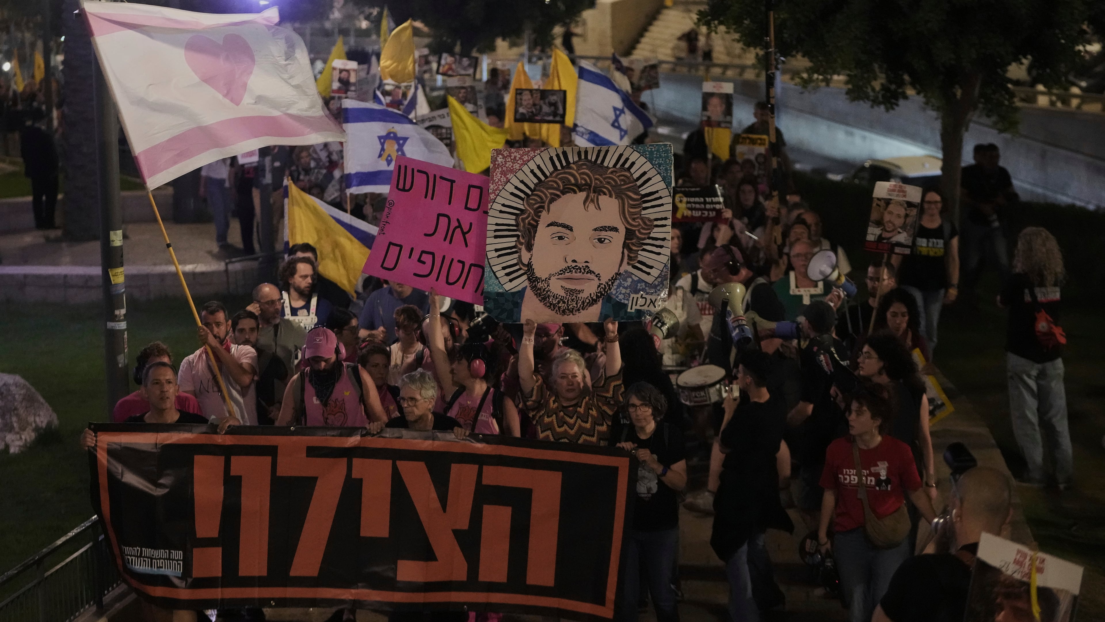 Holding a banner with a message in Hebrew asking for help, relatives and supporters of Israeli hostages held in the Gaza Strip take part in protest demanding their release from Hamas captivity and calling for an end to the war, outside the Old City of Jerusalem, Saturday, Sept. 20, 2025. (AP Photo/Mahmoud Illean)