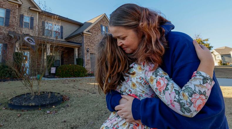 Angela Cassandra hugs her daughter, Avery, upon her return from school on Wednesday, Nov. 12, 2025. Angela, 41, had undergone a transplant 11 years earlier, which enabled her to continue living, marry her boyfriend, Daniel, and later have Avery. After having a second transplant earlier this year, she and her family feel profoundly grateful, especially as Thanksgiving approaches. (Miguel Martinez/AJC)