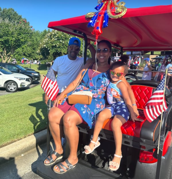 Reginald Wesley (from left), Tiffany Roache and Tilly Roache enjoyed a golf cart parade near Lake Oconee on July Fourth. The family adorned their electric vehicle in flags and Wesley made sure a boom box was ready to play some tunes. (Courtesy)
