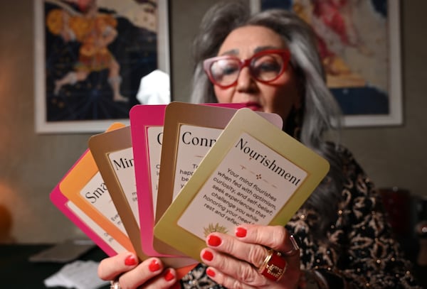 Rolene Jaffe, holding her Rise & Radiate oracle cards, describes her work as getting out of the mind and dropping into the body. “The spiritual journey is not an easy one,” she says. (Hyosub Shin/AJC)