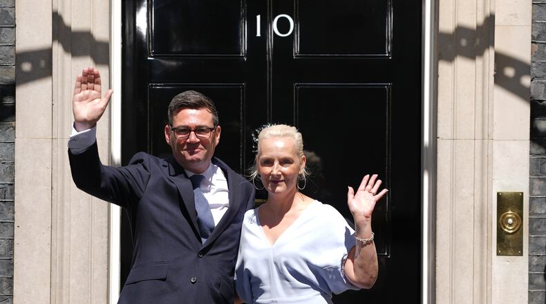 Britain's new Prime Minister Andy Burnham and his wife Marie-France van Heel wave as they arrive at 10 Downing Street in London, Monday, July 20, 2026.(AP Photo/Kirsty Wigglesworth)