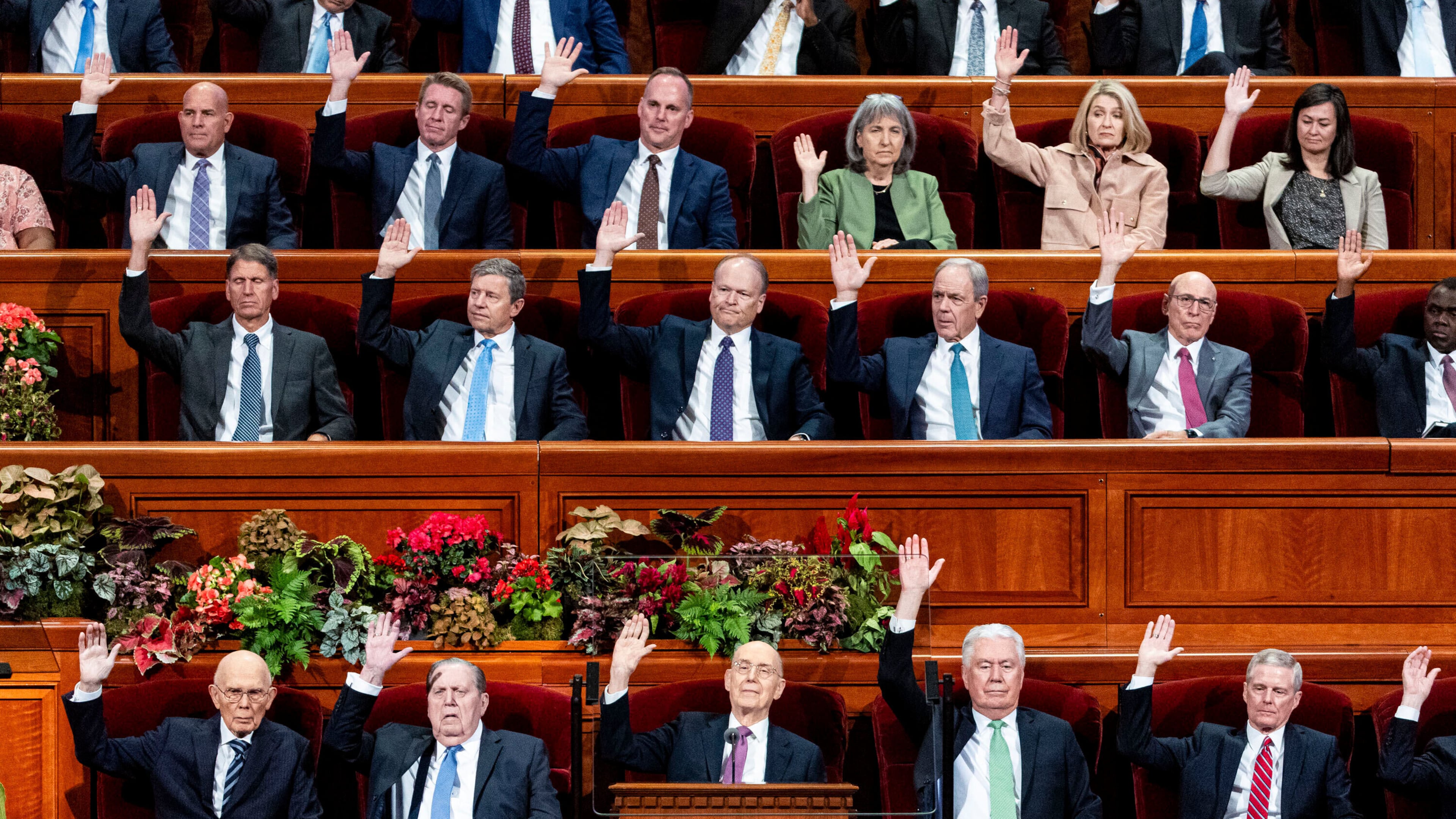 Elder Henry B. Eyring, bottom center, of the Quorum of the Twelve Apostles, and other Church leaders raise their hands as part of a sustaining vote during the morning session of the 195th Semiannual General Conference of The Church of Jesus Christ of Latter-day Saints at the Conference Center in Salt Lake City on Saturday, Oct. 4, 2025. (Isaac Hale/The Deseret News via AP)