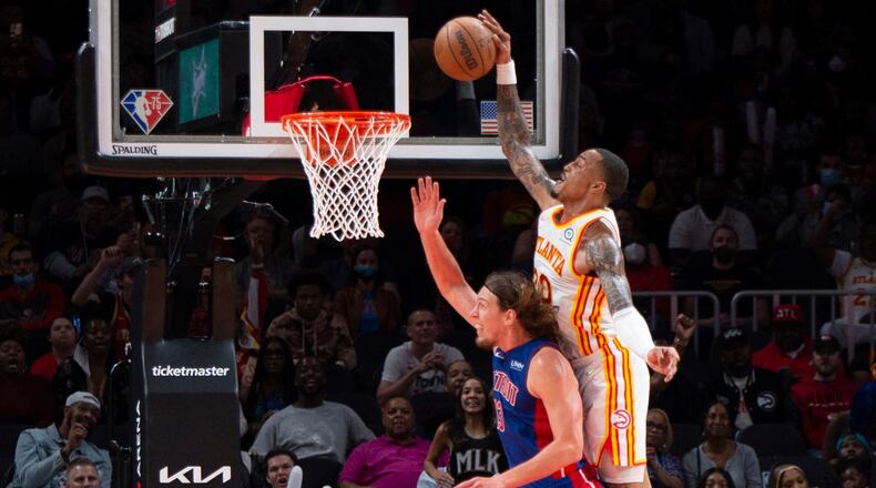 Hawks forward John Collins dunks over Pistons forward Kelly Olynyk during the second half of the Hawks' win over the Pistons Monday at State Farm Arena. (AP Photo/Hakim Wright Sr.)