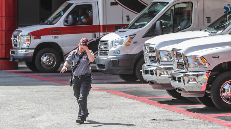 May 9, 2019 : Atlanta: A Grady ambulance driver walks away from ambulances lined up at Grady Hospital in Atlanta on Thursday May 9, 2019. Emergency Critics say Georgia's system of selecting ambulance providers needs a major overhaul, pointing to concerns -- rampant conflicts, lax oversight, no rules on vetting -- that put Georgians lives at risk at the most critical hour. JOHN SPINK/JSPINK@AJC.COM