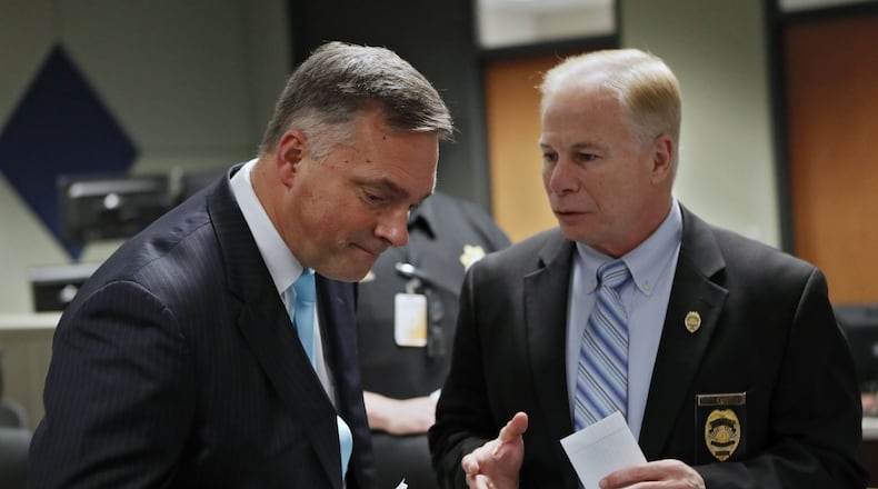 Acting Cobb District Attorney John Melvin (left) and Cobb County Police Chief Michael Register confer before announcing an indictment charging 11 alleged members of the criminal street gang known as “1831” with crimes, including racketeering, gang act violations, armed robbery, aggravated assault, battery, and narcotics and firearm charges. Most of those charged were taken into custody Friday at various locations in Cobb, Paulding, Fulton, Fayette and Baldwin Counties, including Milledgeville. BOB ANDRES / BANDRES@AJC.COM