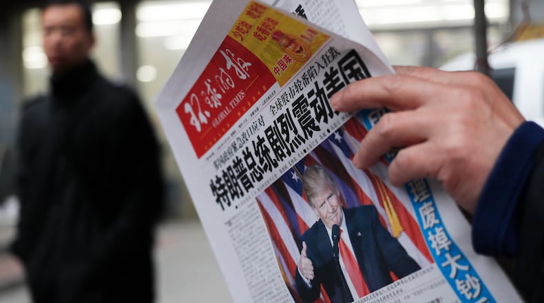 A man reads a newspaper with the headline of "U.S. President-elect Donald Trump delivers a mighty shock to America" at a news stand in Beijing. AP/Andy Wong