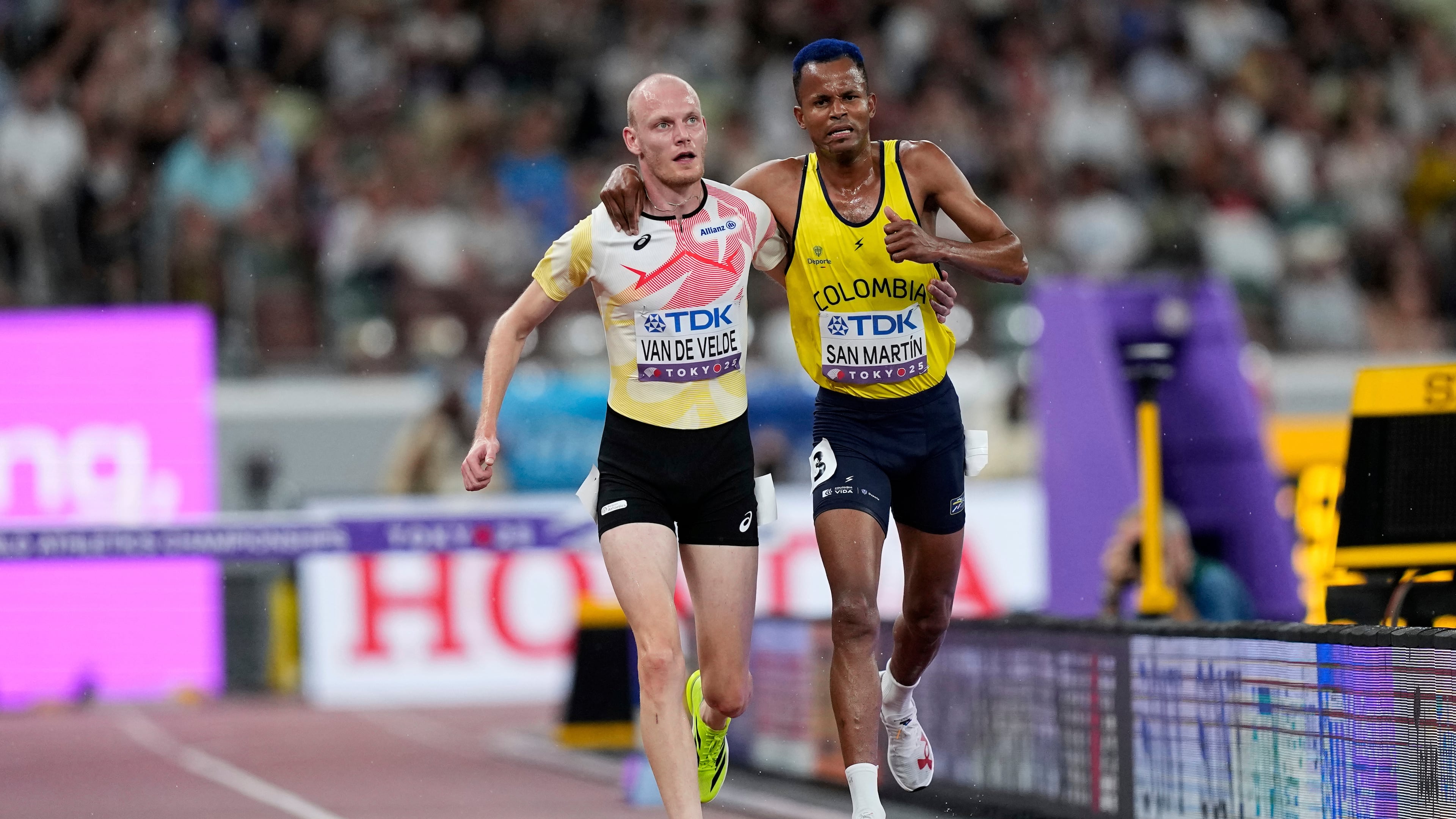 Colombia's Carlos San Martin and Belgium's Tim Van De Velde help each other to the nine during a men's 3,000 meters steeplechase heat at the World Athletics Championships in Tokyo, Saturday, Sept. 13, 2025. (AP Photo/Petr David Josek)