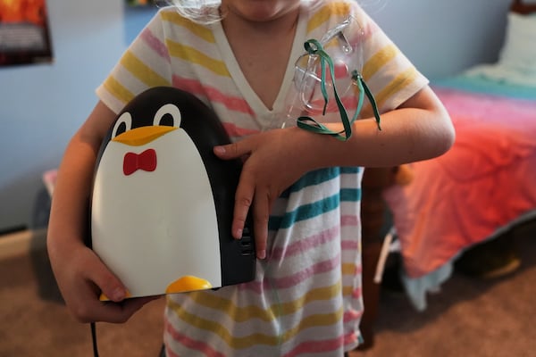 Eliza Ethridge, 5, holds her nebulizer Thursday, April 10, 2025, in Evansville, Ind. (AP Photo/Joshua A. Bickel)