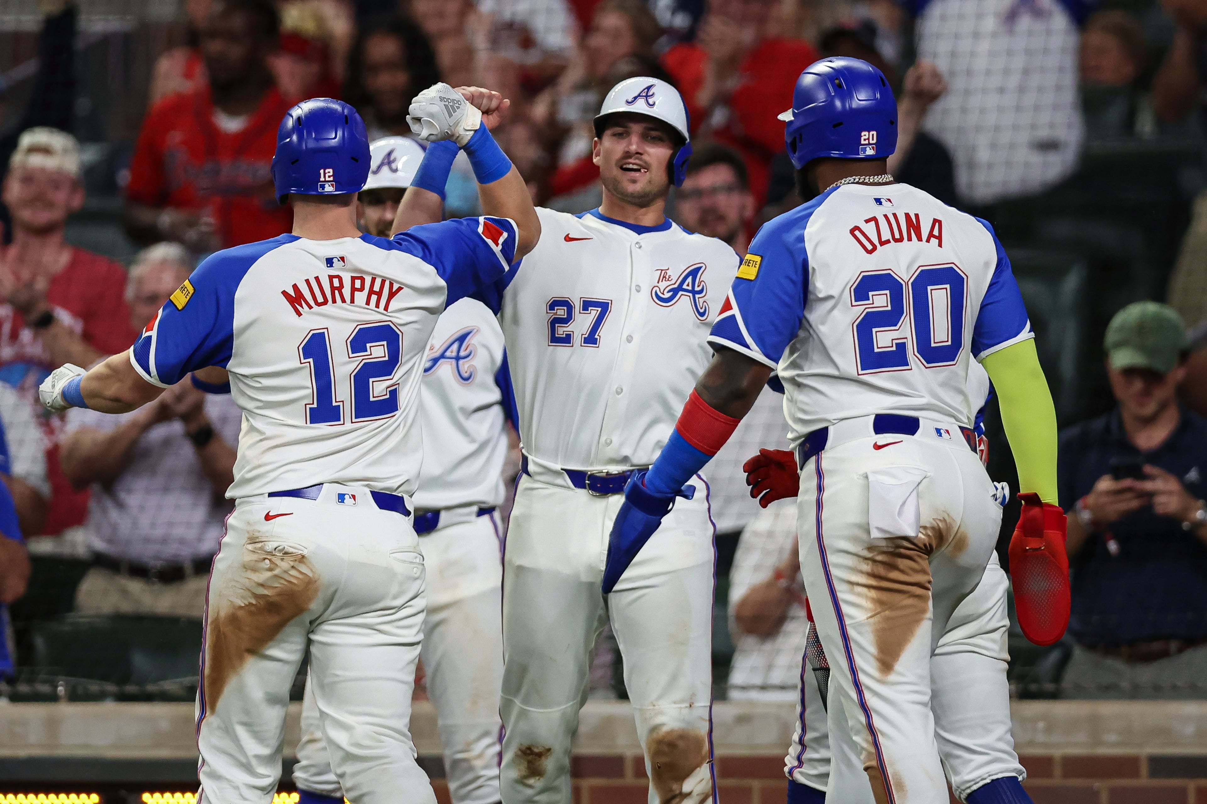 Atlanta Braves' Sean Murphy (12) celebrates with Austin Riley (27) and Marcell Ozuna (20) after hitting a grand slam in the seventh inning of a baseball game against the Philadelphia Phillies, Saturday, June 28, 2025, in Atlanta. (AP Photo/Colin Hubbard)