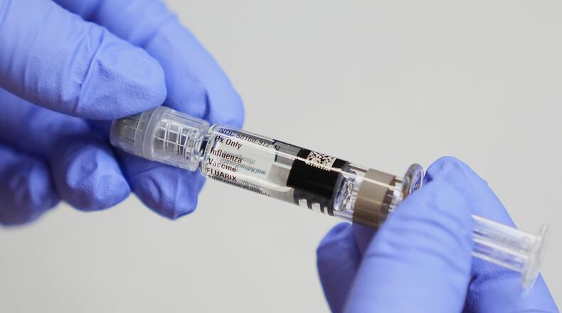 FILE - A certified medical assistant holds a syringe for a flu vaccine at a clinic in Seattle, on Wednesday, Sept. 10, 2025. (AP Photo/Lindsey Wasson, File)