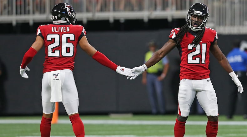 Isaiah Oliver and Desmond Trufant high five each other.  Christina Matacotta/Christina.Matacotta@ajc.com