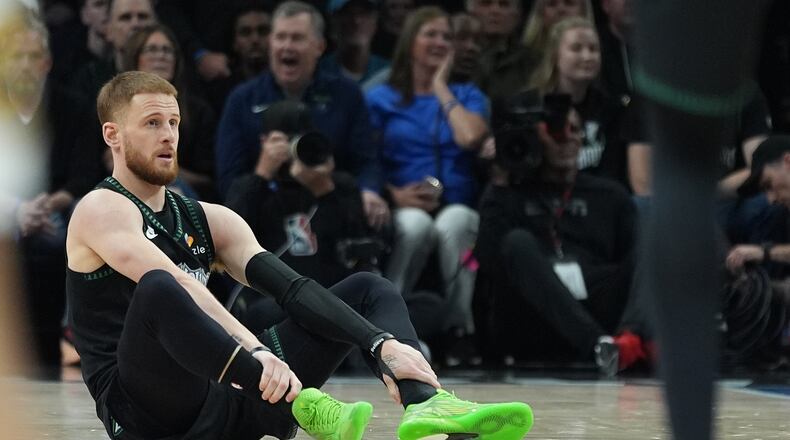 Minnesota Timberwolves guard Donte DiVincenzo (0) sits on the court after sustaining an injury during the first half of Game 4 of a first-round NBA basketball playoff series against the Denver Nuggets, Saturday, April 25, 2026, in Minneapolis. (AP Photo/Abbie Parr)
