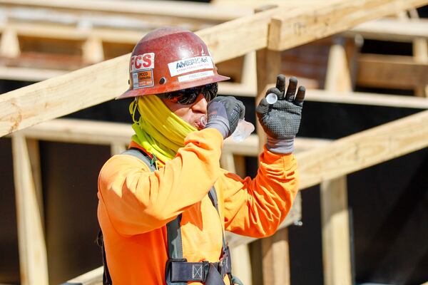 A construction worker takes a break to hydrate at a construction site in downtown Atlanta on Monday, July 28, 2025. (Miguel Martinez/AJC)