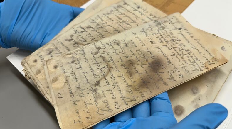 State Historical Society of North Dakota Deputy State Archivist Lindsay Meidinger holds pages of the diary of Mark Kellogg, a reporter killed during the Battle of the Little Bighorn in 1876, at the North Dakota Heritage Center and State Museum in Bismarck, N.D., Wednesday, June 24, 2026. (AP Photo/Jack Dura
