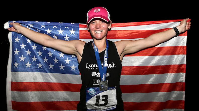 FILE - In this Jan. 30, 2016 file photo, Becca Pizzi of the United States, holds an American flag after winning the seventh and final leg of the World Marathon Challenge -- seven marathons in seven days on seven continents -- in Sydney, Australia. Pizzi, from Belmont, Mass., is preparing to tackle the odyssey again on Jan. 30, 2018. If she completes it, she'll become the first to repeat the feat. (AP Photo/Rob Griffith, File)
