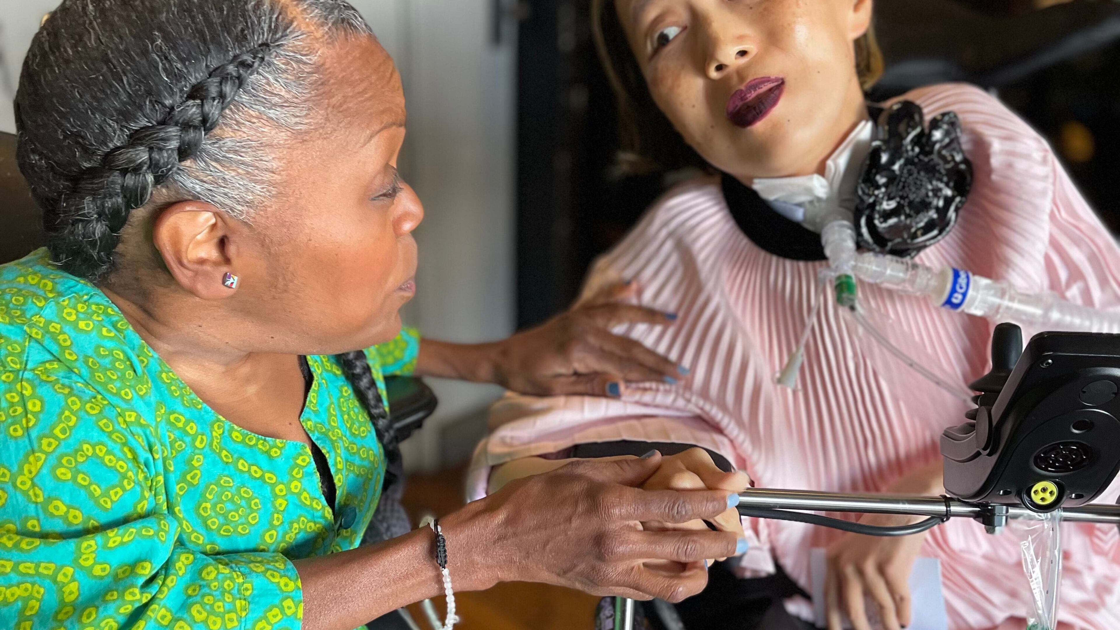 This March 2024 photo provided by Sandy Ho shows Yomi Young, left, speaking with Alice Wong at Wong's 50th birthday party in San Francisco. (Sandy Ho via AP)