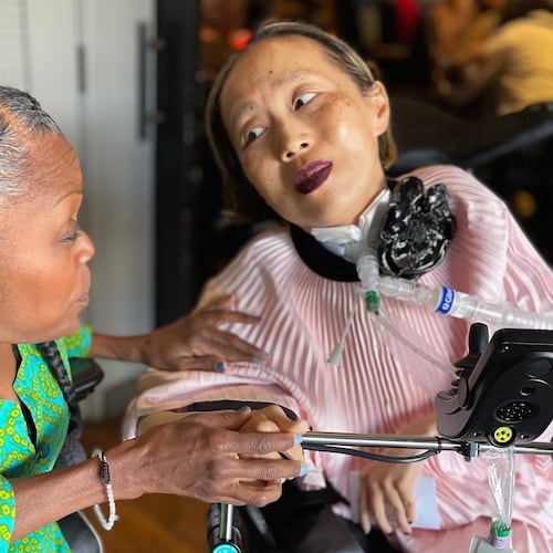 This March 2024 photo provided by Sandy Ho shows Yomi Young, left, speaking with Alice Wong at Wong's 50th birthday party in San Francisco. (Sandy Ho via AP)
