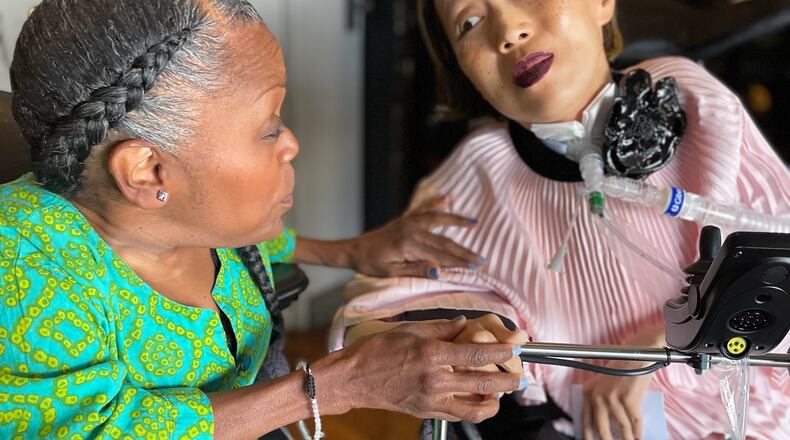 This March 2024 photo provided by Sandy Ho shows Yomi Young, left, speaking with Alice Wong at Wong's 50th birthday party in San Francisco. (Sandy Ho via AP)