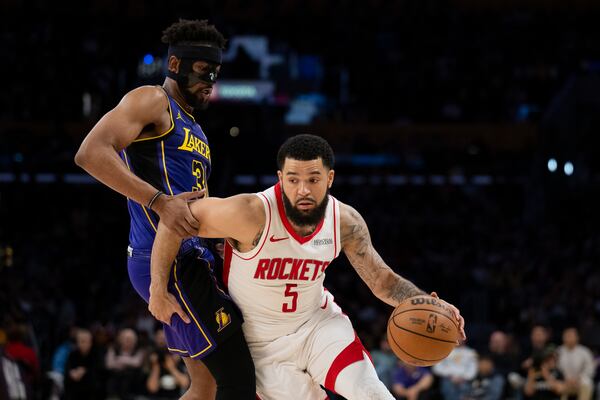 Houston Rockets guard Fred VanVleet (5) drives to the basket past Los Angeles Lakers guard Jordan Goodwin (30) during the first half of an NBA basketball game in Los Angeles, Monday, March 31, 2025. (AP Photo/Kyusung Gong)