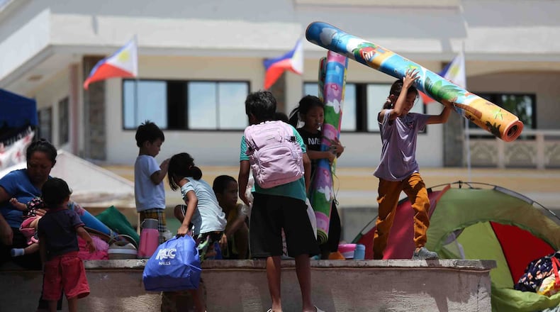Residents take shelter in a field at a municipal hall in Sarangani province, Philippines, Wednesday, June 10, 2026. (AP Photo/Basilio Sepe)