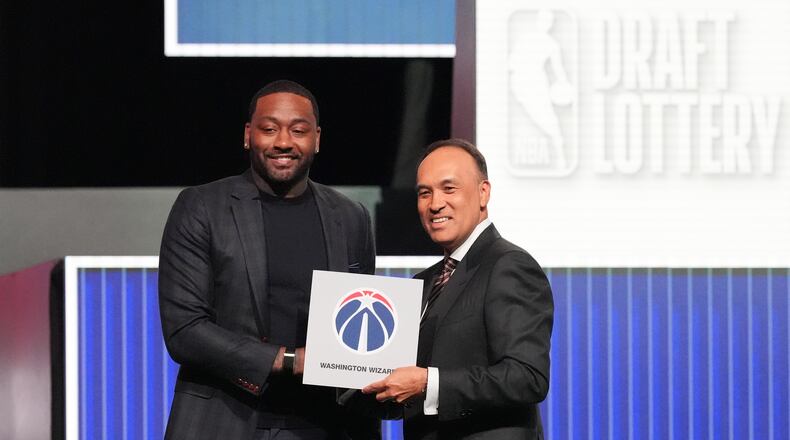 Washington Wizards' John Wall, left, and NBA Deputy Commissioner Mark Tatum, pose for photos after Tatum announced that the Wizards had won the first pick in the NBA basketball draft lottery in Chicago, Sunday, May 10, 2026. (AP Photo/Nam Y. Huh)