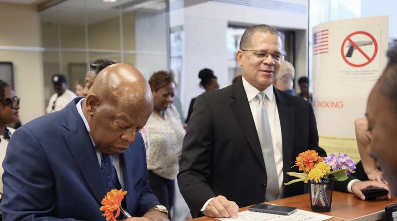 Congressman John Lewis (left) and Fulton County Chairman John Eaves sign in to vote. Eaves has embraced a role as convener of mayors, and will add another one if South Fulton voters create a new city. BOB ANDRES /BANDRES@AJC.COM AJC File Photo