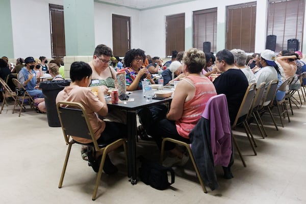 Gabby Williams (center) chats with friends as they enjoy a meal together during the Southern Fried Queer Pride Spaghetti Dinner and Bingo at the Little 5 Points Community Center on Wednesday, June 24, 2026, in Atlanta. (Estela Muñoz/AJC)