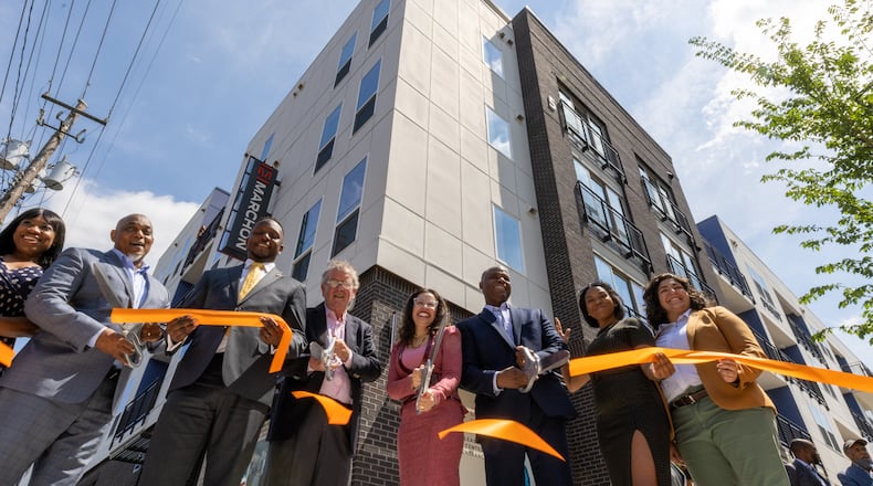 People cut a ribbon during the dedication for the new commercial and residential development at the King Memorial Station on Friday, May 19, 2022. (Steve Schaefer / steve.schaefer@ajc.com)