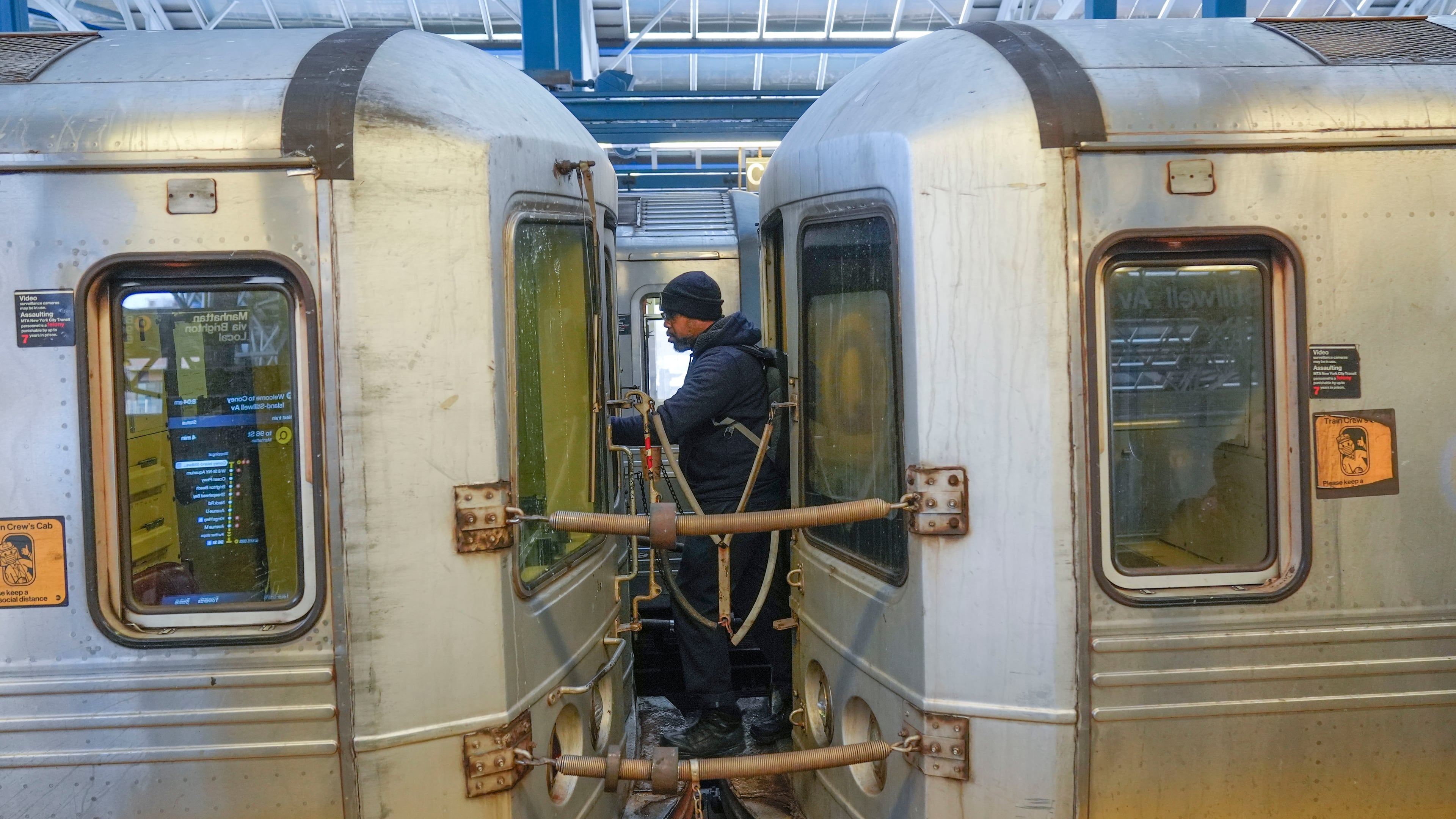FILE - A train conductor walks between subway cars at a station in the Coney Island section of New York, Thursday, Jan. 23, 2025. (AP Photo/Seth Wenig, File)