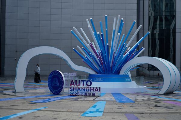 An attendee arrives to the Auto Show in Shanghai, Wednesday, April 23, 2025. (AP Photo/Ng Han Guan)