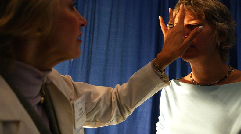 A doctor checks a patient for signs of skin cancer.