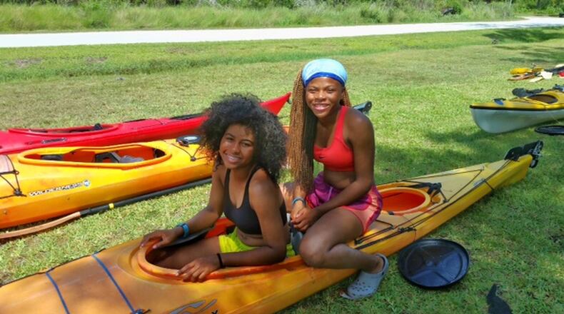 Kamryn Boone (left) and Jurnee Miller take a break while cleaning their kayak at base camp at North Carolina Outward Bound School. Kamryn attends Atlanta’s Grady High School, Jurnee attends Charles R. Drew Charter School. PHOTO: Angela Tuck/atuck@ajc.com