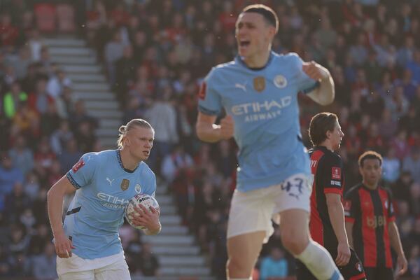 Manchester City's Erling Haaland, left, celebrates with Manchester City's Phil Foden, front, after scoring his side's opening goal during the English FA Cup quarterfinal soccer match between Bournemouth and Manchester City at the Vitality stadium in Bournemouth, England, Sunday, March 30, 2025. (AP Photo/Ian Walton)