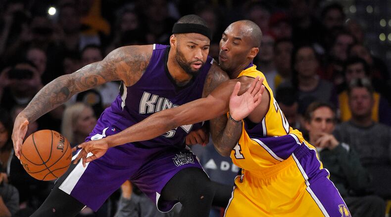 Los Angeles Lakers forward Kobe Bryant, right, reaches in on Sacramento Kings center DeMarcus Cousins during the second half of an NBA basketball game Wednesday, Jan. 20, 2016, in Los Angeles. The Kings won 112-93. (AP Photo/Mark J. Terrill)