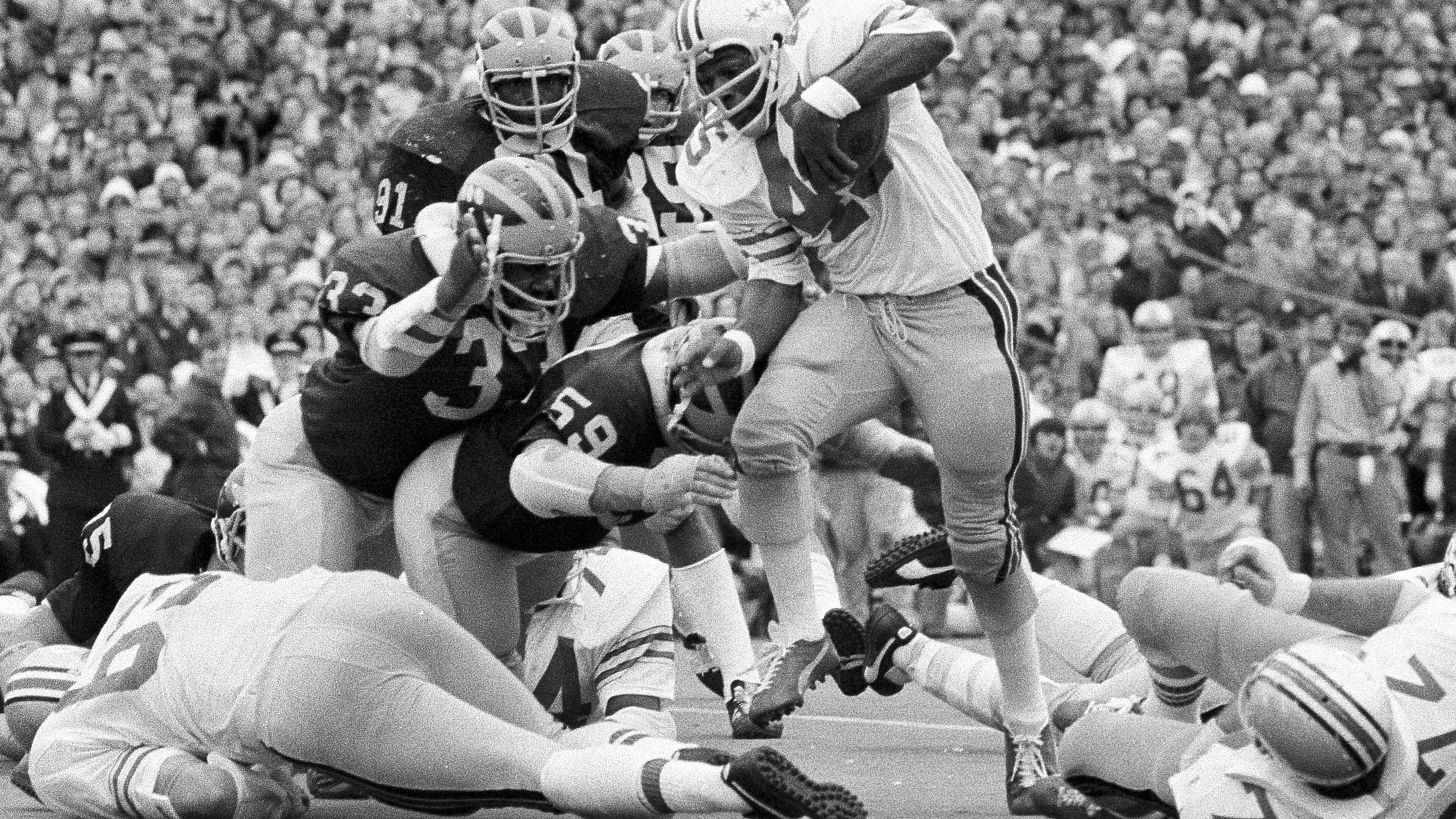 FILE - Ohio State's Archie Griffin picks up some of his game-high 163 yards against Michigan during an NCAA college football game in Ann Arbor, Mich., as Michigan's Walt Williamson (91), Carl Russ (33) and Steve Strinko (59) defend. (AP Photo/File)