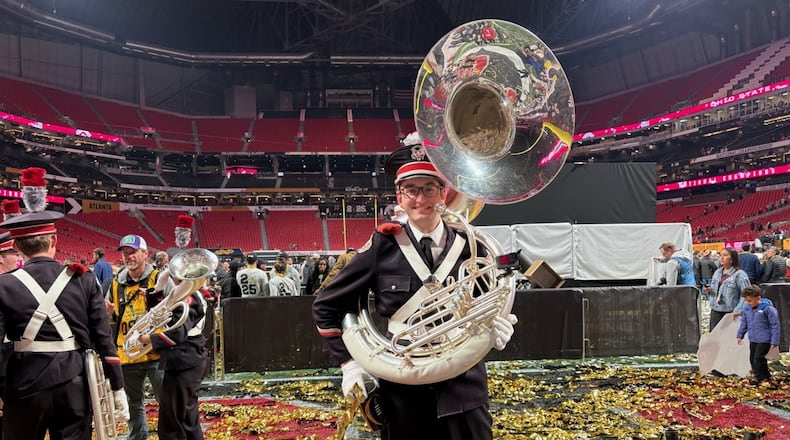 Ohio State marching band member Mike Sterling poses on the Mercedes-Benz Stadium field after the Buckeyes' 34-23 win over Notre Dame in the College Football Championship title game Jan. 20, 2025. (AJC photo by Ken Sugiura)