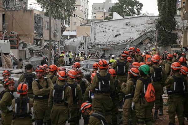 Rescue workers, police and military inspect the site where an Iranian missile struck in Bnei Brak, near Tel Aviv, Israel, Monday, June 16, 2025. (AP Photo/Leo Correa)