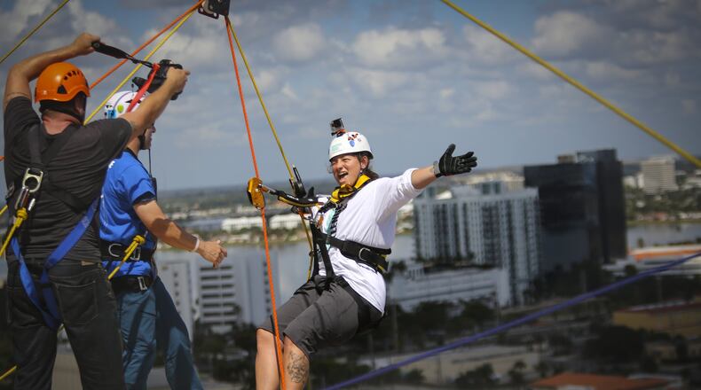 Kelly Beringson of Delray Beach steps off the roof of CityPlace Tower before rappelling down the building during the Shatterproof Challenge in West Palm Beach on Saturday, April 4, 2015. “It was so much fun,” she said. “I would do it again.” (Bruce R. Bennett / The Palm Beach Post)