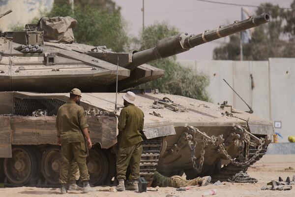 Israeli soldiers work on a tank at a staging area near the border with the Gaza Strip, in southern Israel, Tuesday, July 1, 2025. (AP Photo/Ariel Schalit)