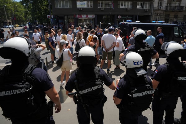 Serbian riot police officers guard intersection after remove street blockades that was set up as part of a protest after a massive rally demanding an early parliamentary election in Belgrade, Serbia, Friday, July 4, 2025. (AP Photo/Darko Vojinovic)