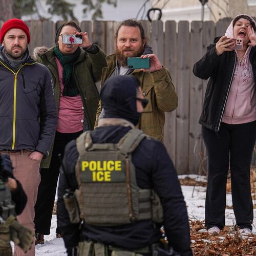 Observers film while federal agents conduct immigration enforcement operations, on Thursday, Feb. 5, 2026, in Minneapolis. (AP Photo/Ryan Murphy)